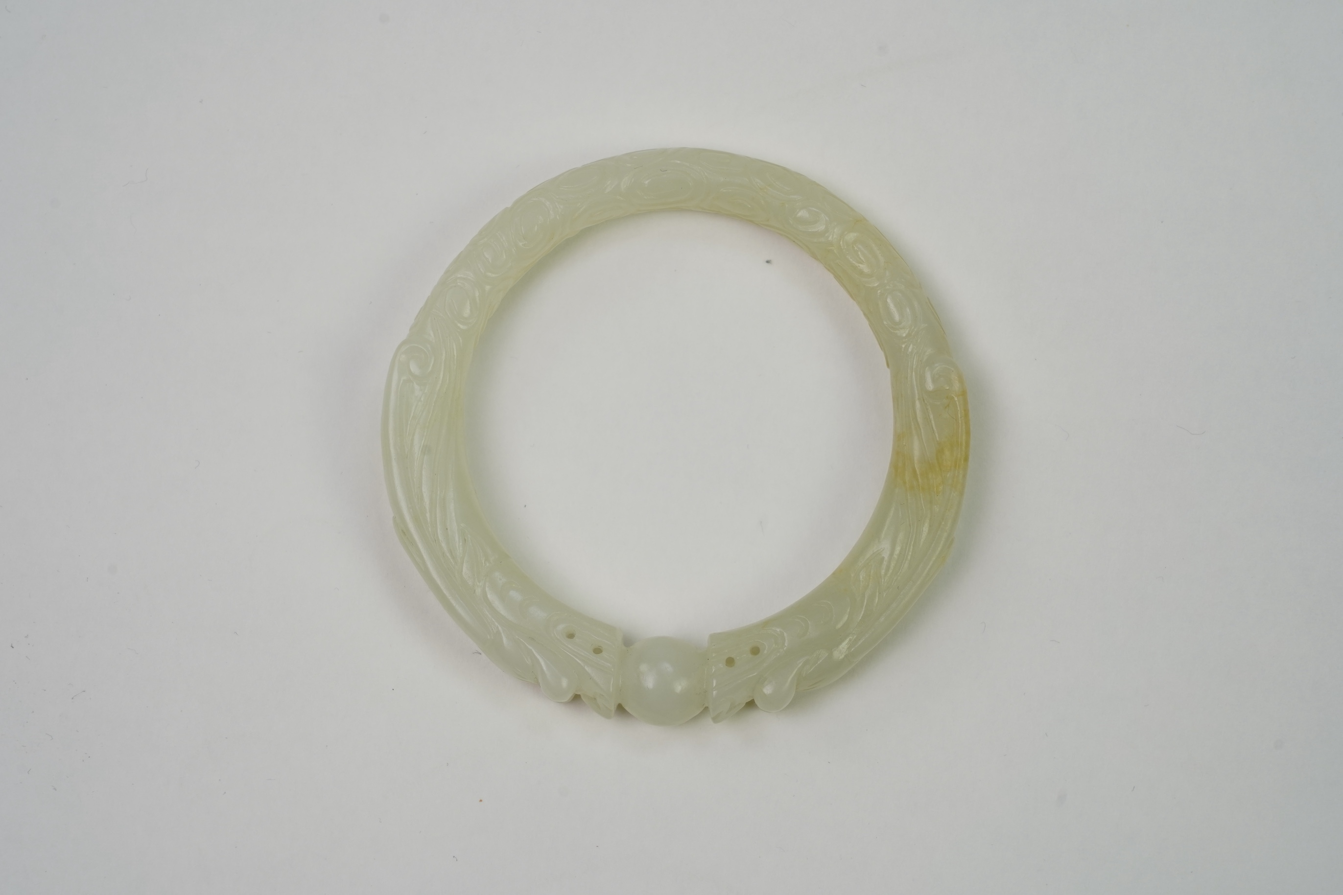 A Chinese pale celadon jade ’dragon’ bangle